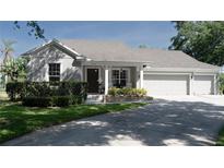 Charming home with a well-manicured lawn, flower beds, covered porch, and a two-car garage at 6350 Sedona Leaf Ct, Windermere, FL 34786