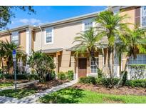 Inviting townhome with a neutral color scheme, front shrubs, and beautiful palm trees at 774 Chelsea Dr, Davenport, FL 33897