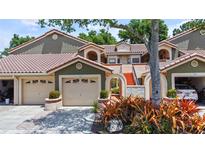Inviting home exterior featuring a neutral color palette, tile roof, and attached garage at 7768 Sugar Bend Dr # 7768, Orlando, FL 32819