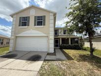 Two-story home featuring a two-car garage, green shutters, and a well-maintained lawn at 786 Crystal Bay Ln, Orlando, FL 32828