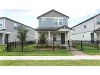 Charming two-story home boasts a well-maintained lawn and sleek black fence, creating a welcoming curb appeal at 12272 Bracco St, Winter Garden, FL 34787