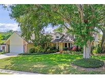 Charming home boasts lush landscaping, mature trees, and a well-manicured lawn, adding to its curb appeal at 1440 Suzanne Way, Longwood, FL 32779