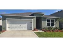 Charming single-story home featuring a well-manicured lawn, two car garage, and inviting front entrance at 1596 Park Side Ave, Kissimmee, FL 34744