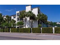 Elegant condominium building featuring white exterior, palm trees, and manicured hedges at 200 Carolina Ave # 201, Winter Park, FL 32789