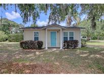Charming single-story home featuring a vibrant blue door and well-maintained landscaping at 200 W 27Th St, Sanford, FL 32773