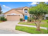 Charming two-story home featuring a well-maintained lawn, a two-car garage, and a vibrant blue front door at 3468 Woodley Park Pl, Oviedo, FL 32765