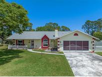 Charming single-story home with a well-manicured lawn and two-car garage at 5583 Miles Dr, Port Orange, FL 32127