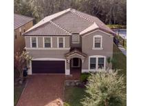 Charming two-story home with a tile roof, manicured lawn, and an attached two-car garage at 8924 Bengal Ct, Kissimmee, FL 34747