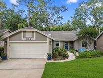 Charming home featuring a manicured front yard, a two-car garage, and beautiful landscaping at 903 Oak Leaf Ct, Altamonte Springs, FL 32714
