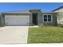 Charming single-story home featuring a two-car garage and well-maintained front lawn at 1596 Park Side Ave, Kissimmee, FL 34744