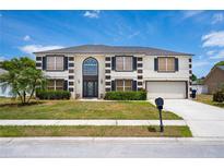 Charming two-story home featuring a well-manicured lawn and a classic architectural style at 114 Shaddock Dr, Auburndale, FL 33823