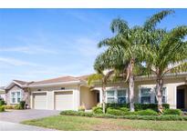 Attractive home exterior with lush landscaping, mature palm trees, and a tiled roof at 1161 Trappers Trail Loop, Davenport, FL 33896