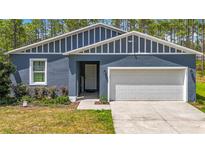 Charming single-story home features a well-maintained lawn, two car garage, and welcoming entrance at 13297 Sw 69Th Pl, Ocala, FL 34481