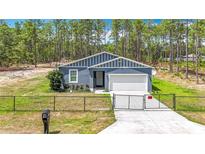 Charming single-Gathering home with a manicured lawn, fenced front yard, and a two-car garage at 13297 Sw 69Th Pl, Ocala, FL 34481