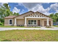 Charming single-story home featuring a decorative gable, covered front porch, and a well-manicured lawn at 1390 E Wabash St, Bartow, FL 33830