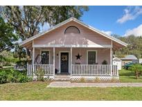 Charming pink single-story home featuring a covered porch with a swing and decorative elements at 2305 S Magnolia Ave, Sanford, FL 32771