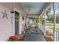 Inviting front porch with seating, ceiling fan, and charming decor, enhancing the home's curb appeal and creating a welcoming entrance at 2305 S Magnolia Ave, Sanford, FL 32771