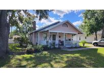 Charming cottage-style home featuring a cozy front porch with a swing and well-manicured landscaping at 2305 S Magnolia Ave, Sanford, FL 32771