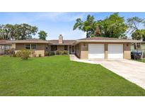 Charming single-story home with a well-maintained lawn and a two-car garage at 2618 Grassmere Ln, Orlando, FL 32808