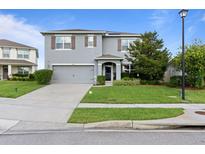 Charming two-story home with manicured lawn, gray stucco, and a two car garage at 4054 Silverstream Ter, Sanford, FL 32771
