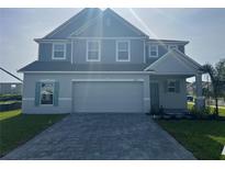 Beautiful two-story home featuring a well-manicured lawn and a paved driveway at 4891 Lyric Dr, Mascotte, FL 34753