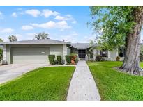 Charming single-story home with a well-manicured lawn and mature landscaping at 715 Roughbeard Rd, Winter Park, FL 32792
