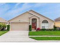 Charming single-story home with a well-manicured lawn, arched windows and a two car garage at 128 Brushcreek Dr, Sanford, FL 32771