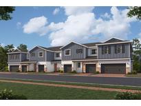 Charming row of modern townhouses with gray siding, stone accents, and attached garages at 14938 Harvest St, Orlando, FL 32824