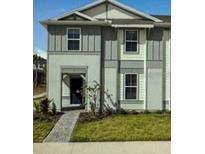 Charming two-story home featuring a gray exterior, well-kept lawn, and inviting entryway at 16069 Blue Wave Way, Clermont, FL 34714