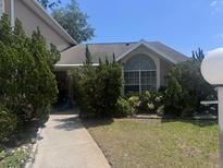 Charming single-story home with well-manicured landscaping and a lovely curved window at 1621 Emily Ct, Kissimmee, FL 34744