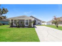 Charming single-story home with a well-manicured lawn and long driveway at 1653 Turtle Rock Dr, Lakeland, FL 33803