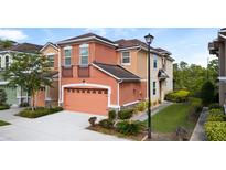 Inviting two-story townhome with a two-car garage and colorful peach and beige exterior at 2112 Rookery Ln, Sanford, FL 32773