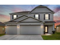 Charming two-story home with a three-car garage and manicured lawn, perfect for families at 242 Milestone Dr, Haines City, FL 33844