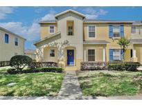 Charming two-story townhome featuring a blue front door, well-maintained landscaping, and a welcoming entrance at 2460 Formax Dr, Orlando, FL 32828