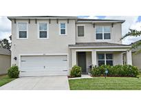 Charming two-story home features a two car garage, well-manicured lawn and lush shrubbery at 2524 Harmonia Hammock Rd, Harmony, FL 34773