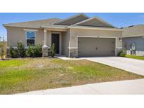 Charming single-story home featuring a two-car garage, manicured lawn, and well-maintained landscaping at 292 Spirit Landings Cir, Winter Haven, FL 33880