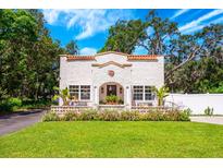 Charming stucco home with terra cotta roof details and a lush, landscaped front yard at 306 Albany Ave, Deland, FL 32724