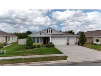 Beautiful single-Gathering home with well-maintained landscaping, three-car garage, and covered front porch at 449 Halter Dr, Apopka, FL 32712