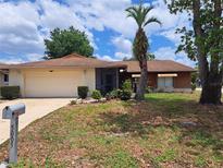 Charming single-story home with a two-car garage, screened entrance, and a well-manicured front yard at 5005 Lindsay Ct, Orlando, FL 32821