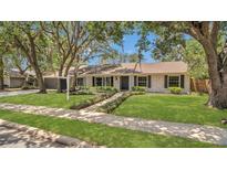 Charming single-story home with a well-manicured lawn, mature trees, and inviting curb appeal at 702 N Sweetwater Blvd, Longwood, FL 32779