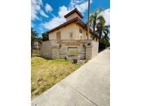 Condominium complex entrance with stone signage, landscaping, and fountain feature at 710 Ridenhour Cir # 710, Orlando, FL 32809