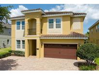 Charming two-story home with a brown garage door and a beautiful brick driveway at 7519 Marker Ave, Kissimmee, FL 34747