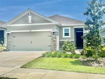 Charming single-Gathering home with a well-maintained lawn, stone accents, and a two-car garage at 7871 Penrose Pl, Wildwood, FL 34785