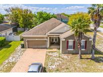 Charming single-story home with a brick driveway, a two-car garage, and two palm trees at 807 Ayden Oak Ln, Ocoee, FL 34761