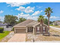 Charming single-story home showcasing a brick driveway, well-maintained yard and picturesque palm trees at 807 Ayden Oak Ln, Ocoee, FL 34761