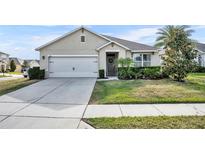 Charming single-story home with a well-manicured lawn, a two-car garage, and a welcoming front entrance at 822 Sheen Cir, Haines City, FL 33844