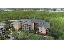 Expansive view of the condos with a treeline and body of water in the background at 9055 Treasure Trove Ln # 501, Kissimmee, FL 34747