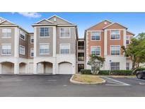 Exterior view of condo buildings with attached garages and reserved parking spaces at 12843 Madison Pointe Cir # 106, Orlando, FL 32821