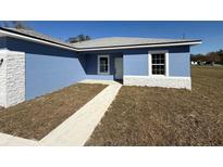 Charming single Gathering home featuring a light blue exterior and sidewalk leading to the front door at 14145 Sw 47Th Ave, Ocala, FL 34481