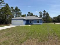 Charming single-story home with blue exterior, white trim, and a well-manicured lawn at 15259 Sw 51St Cir, Ocala, FL 34473